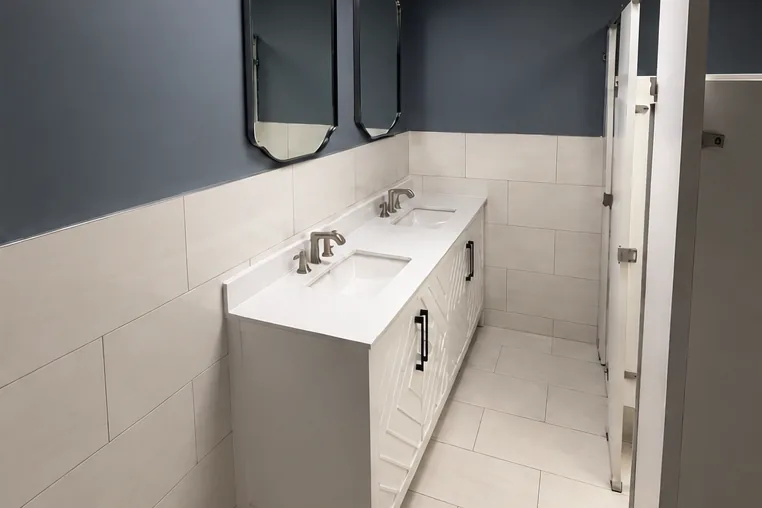 After: the same bathroom with a new vanity, large format tile and fresh paint