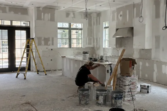 Before: open plan kitchen at drywall stage with the crew finishing joints
