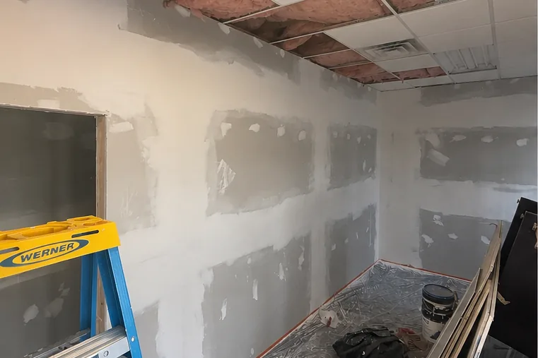 Before: office with the ceiling opened up and drywall repairs in progress