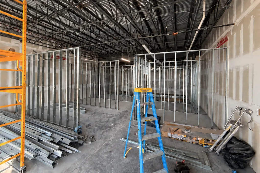 Before: commercial unit at steel framing stage with exposed services overhead