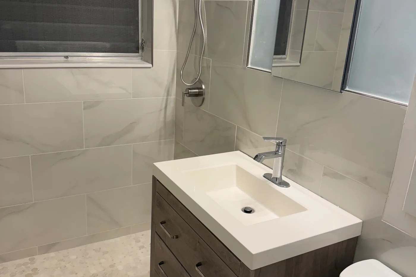 After: the finished bathroom with a floating vanity and tiled shower