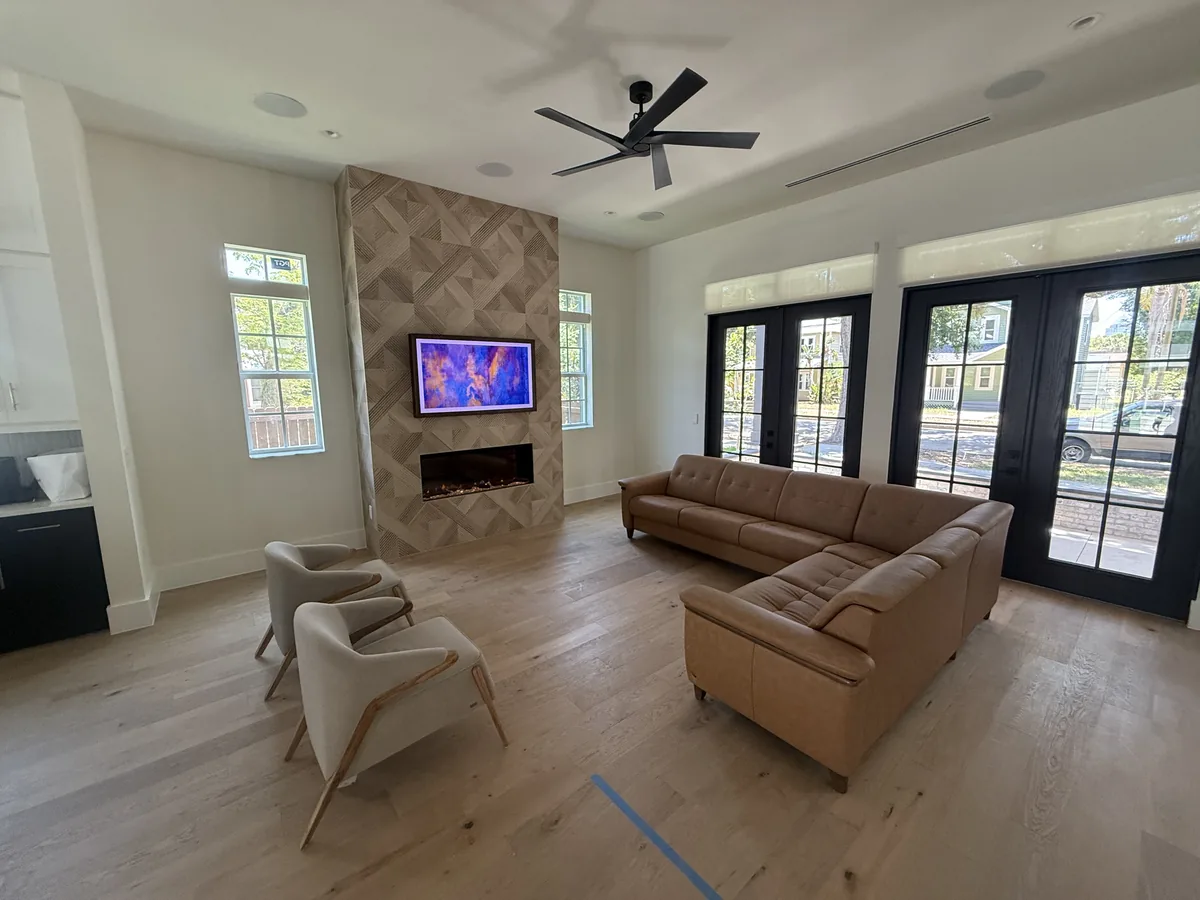 Living room with a tiled fireplace surround and wide-plank wood flooring