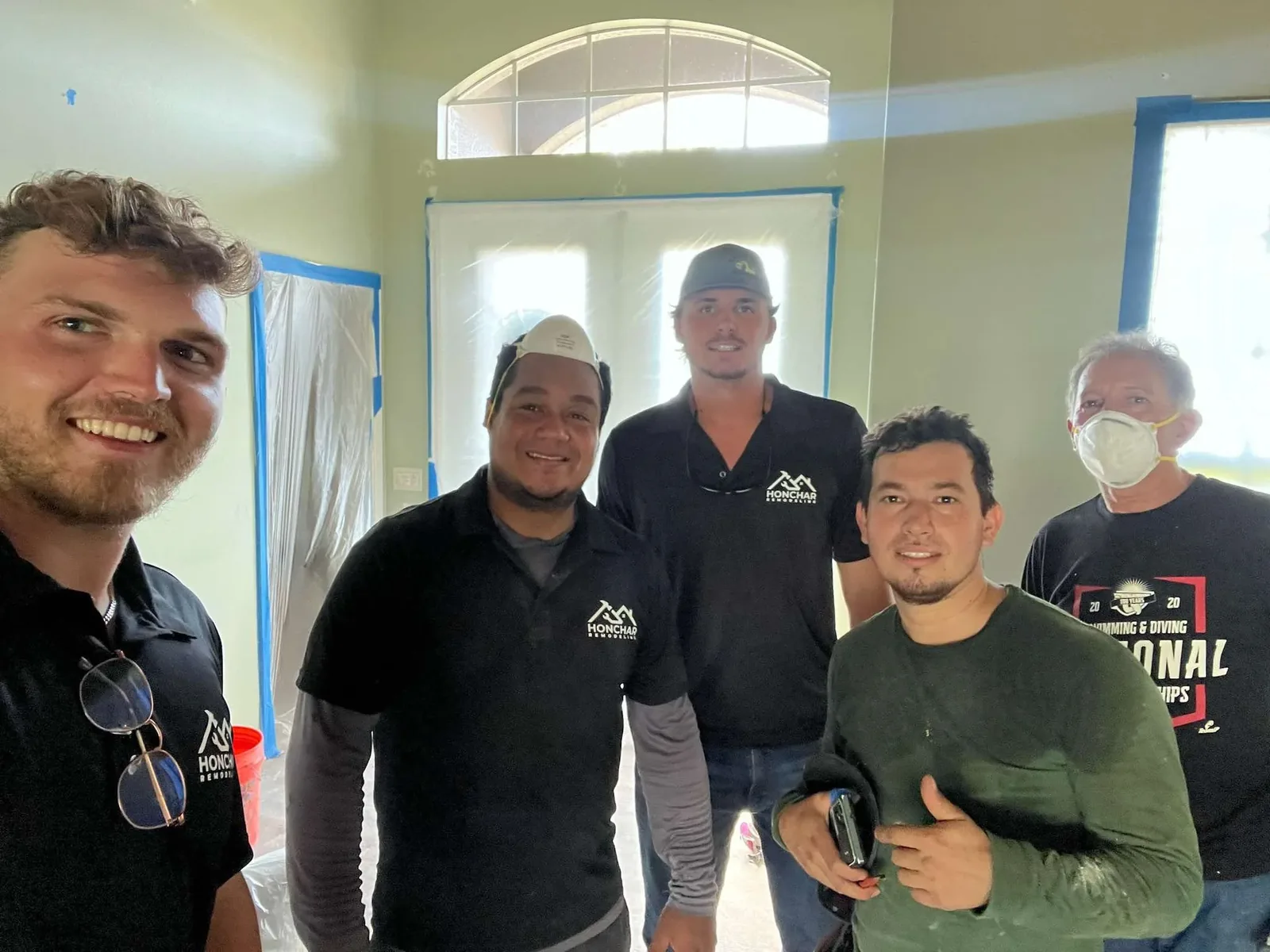 Casey, Tyler and the Honchar Remodeling crew on a job site with masking and floor protection in place